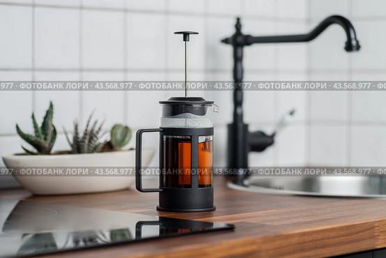 French press in the kitchen. Teapot side view. The tradition of brewing black tea. Close-up photo. Стоковое фото, фотограф KOSIM / Фотобанк Лори