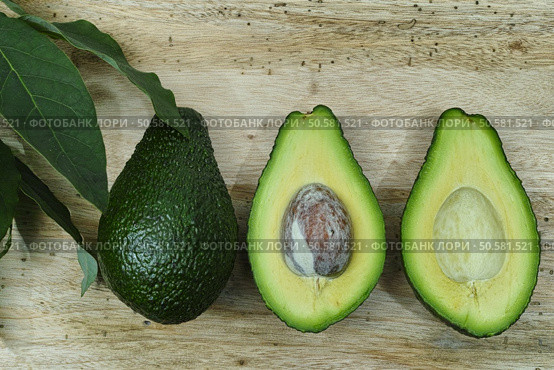 Fresh avocado with avocado leaves on teak wood table top. Стоковое фото, агентство Ingram Publishing / Фотобанк Лори