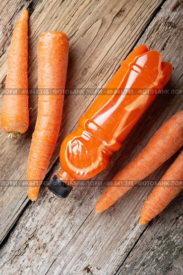 fresh carrot juice with carrots around old style wooden background . Стоковое фото, агентство Ingram Publishing / Фотобанк Лори