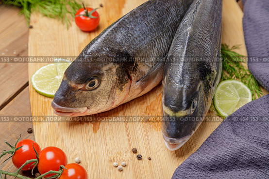 Fresh dorado fish, on a wooden board, two heads close-up. Стоковое фото, фотограф Юрий Поздников / Фотобанк Лори