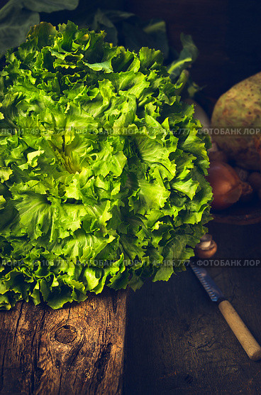 fresh lettuce head on rustic kitchen table over wooden background. Стоковое фото, агентство Ingram Publishing / Фотобанк Лори