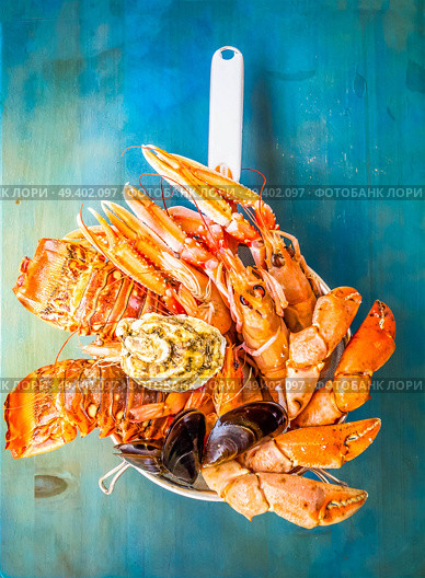 Fresh seafood catch of lobsters, crabs, and langostines on blue background, retro toned. Fresh seafood on blue background. Стоковое фото, агентство Ingram Publishing / Фотобанк Лори
