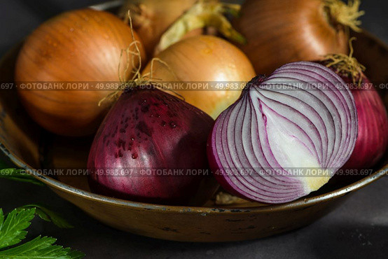 Fresh whole onions in assorted colors and parsley in a small rustic frying pan on kitchen counter top. Стоковое фото, агентство Ingram Publishing / Фотобанк Лори