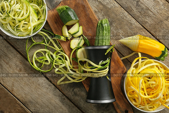 Fresh zucchini spaghetti with spiral grater on wooden table. Стоковое фото, фотограф Pixel_shot / Фотобанк Лори