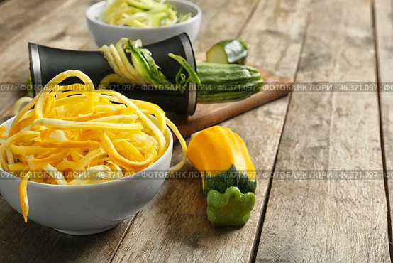 Fresh zucchini spaghetti with spiral grater on wooden table. Стоковое фото, фотограф Pixel_shot / Фотобанк Лори