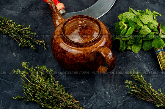 Freshly brewed herbal tea in a glass teapot on a concrete kitchen table. Tea composition with mint leaf.. Glass teapot with herbal tea. Стоковое фото, агентство Ingram Publishing / Фотобанк Лори
