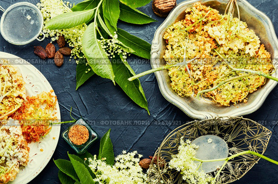Fried elderflower in batter with powdered sugar. Spring flower dessert. Fried elderflower,seasonal food. Стоковое фото, агентство Ingram Publishing / Фотобанк Лори