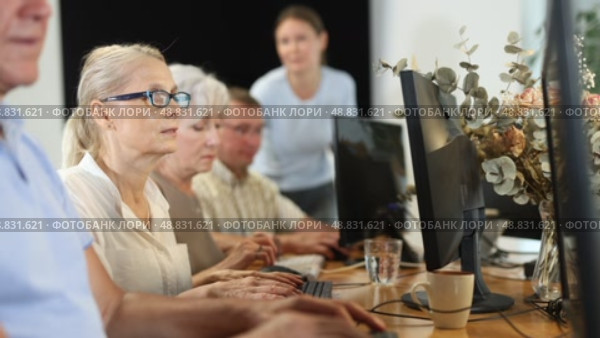 Friendly elderly computer course teacher helping senior woman learn computer. Стоковое видео, видеограф Яков Филимонов / Фотобанк Лори