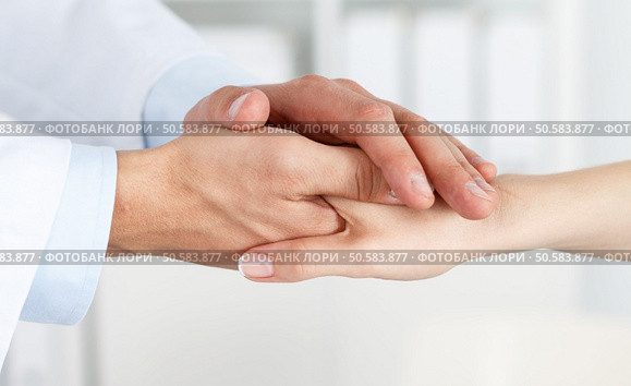 Friendly male doctor’s hands holding female patient’s hand for encouragement and empathy. Partnership, trust and medical ethics concept. Bad news lessening and support. Patient cheering and support. Стоковое фото, агентство Ingram Publishing / Фотобанк Лори