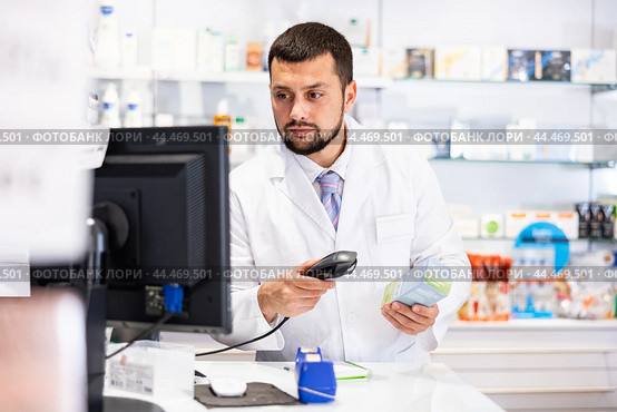Friendly man pharmacist working at cash desk. Стоковое фото, фотограф Яков Филимонов / Фотобанк Лори