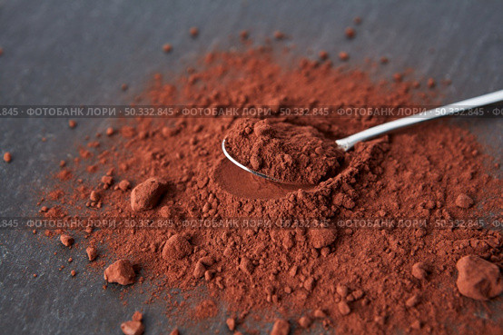 From above of teaspoon placed on heap of bitter cocoa powder of dark brown color on gray background. Organic dry cocoa powder pile. Стоковое фото, агентство Ingram Publishing / Фотобанк Лори