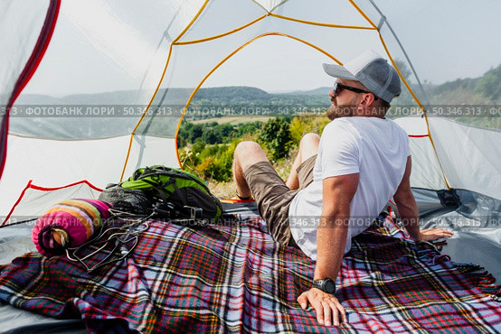front view man tent enjoying view. Стоковое фото, агентство Ingram Publishing / Фотобанк Лори