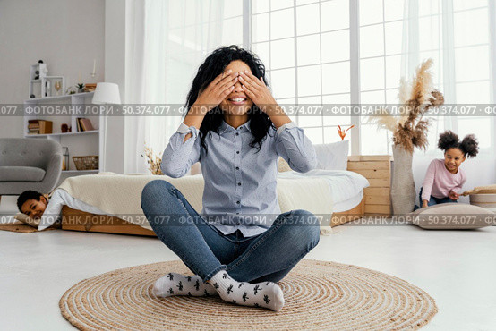 front view smiley mother playing hide seek home with her children. Стоковое фото, агентство Ingram Publishing / Фотобанк Лори