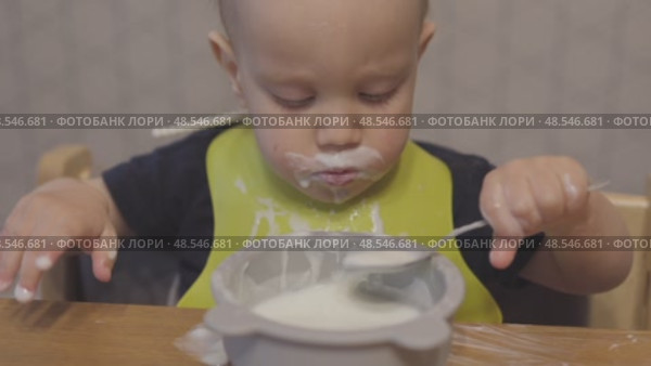 funny baby toddler learning to eat with spoon, child learn eating use teaspoon. Стоковое видео, видеограф Olesia Kondrateva / Фотобанк Лори