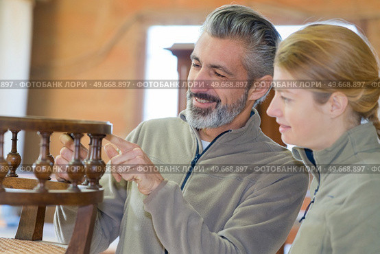 furniture maker in the workshop pointing at chair design. Стоковое фото, агентство Ingram Publishing / Фотобанк Лори