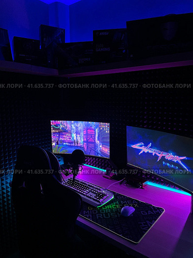 Game Room with Gaming Chair, Two Computer Monitors and Neon lights at Night (2022 год). Редакционное фото, фотограф Антон Колмаков / Фотобанк Лори