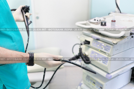 Gastroduodenoscopy distal end and manipulator in the hands of doctors in treatment room. Стоковое фото, фотограф Losevsky Pavel / Фотобанк Лори