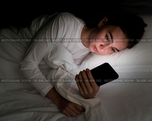 girl night bed with phone. Стоковое фото, агентство Ingram Publishing / Фотобанк Лори