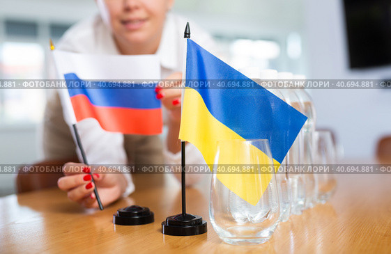 girl sets midget flags of Ukraine and Russia before international negotiations. Стоковое фото, фотограф Яков Филимонов / Фотобанк Лори