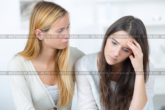 girl supporting her depressed female friend indoors. Стоковое фото, агентство Ingram Publishing / Фотобанк Лори