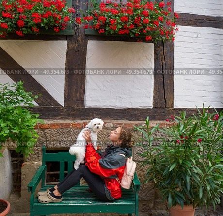 Girl tourist holding Maltese bichon dog in Germany. Girl tourist holding Maltese bichon puppy dog in Germany. Стоковое фото, агентство Ingram Publishing / Фотобанк Лори
