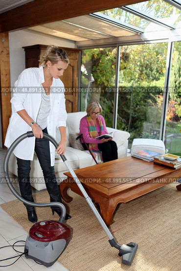 Girl vacuuming for an elderly woman. Стоковое фото, агентство Ingram Publishing / Фотобанк Лори