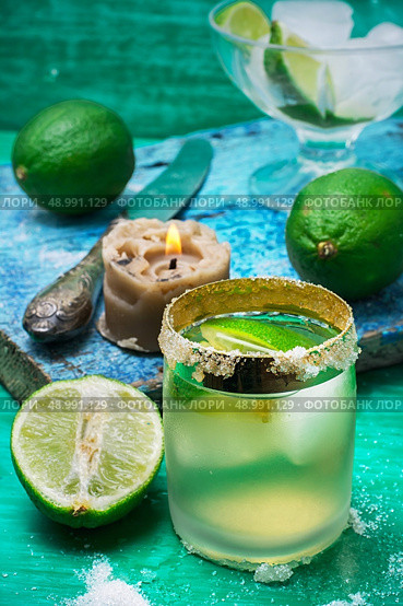 glass alcoholic drink and lime fruits on wooden texture.Selective focus. refreshing cocktail made of rum and lime with ice. Стоковое фото, агентство Ingram Publishing / Фотобанк Лори