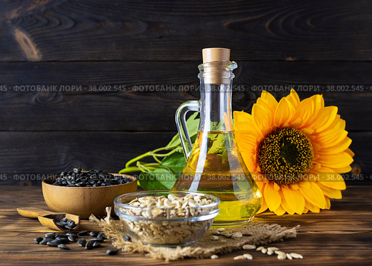 Glass jug with golden sunflower oil on a canvas napkin. Стоковое фото, фотограф Анна Никитина / Фотобанк Лори