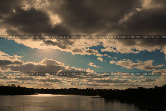 Gloomy evening sky landscape with thunderclouds and water surface of the river.the sun shining through clouds over a lake. Стоковое фото, фотограф Лазаренко Светлана / Фотобанк Лори