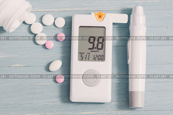 glucometer and pills on gray wooden background. Стоковое фото, фотограф Майя Крученкова / Фотобанк Лори
