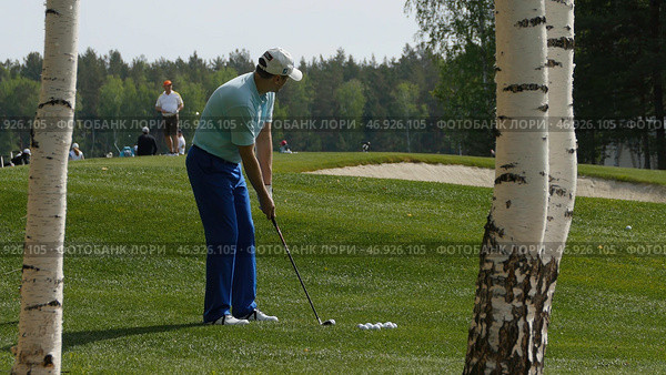 Golfers hit sweeping golf course in the summer. Стоковое фото, фотограф David Kashakhi / Фотобанк Лори