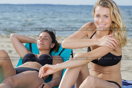 gorgeous blonde in bikini applying suncream on the beach. Стоковое фото, агентство Ingram Publishing / Фотобанк Лори