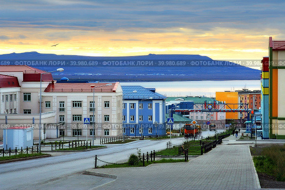 Город Анадырь, Чукотка, Россия. Утренний городской пейзаж. Восход солнца над холмами и красочными зданиями. Анадырь — административный центр Чукотского автономного округа и самый восточный город России. Стоковое фото, фотограф Андрей Степанов / Фотобанк Лори