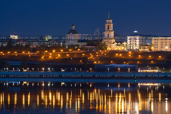 Город Пермь, Пермский край, Россия. Вид на набережную реки Кама и Спасо-Преображенский кафедральный собор. Архитектурная достопримечательность Перми. Красивый ночной городской пейзаж. Вечерние сумерки. В воде отражается свет от уличных фонарей. Путешествия и туризм на Урал. Стоковое фото, фотограф Андрей Степанов / Фотобанк Лори