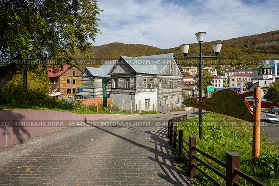 Город Петропавловск-Камчатский, Камчатский край, Россия. Улица ведущая с Никольской сопки в исторический центр города. Вид на старый деревянный дом. Справа указатель с текстом на русском языке «Памятник природы Никольская сопка». Редакционное фото, фотограф Андрей Степанов / Фотобанк Лори