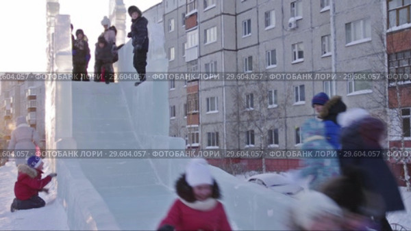 Город Сургут зимой. Дети катаются на ледяной горке. Surgut. City in the winter. Children riding a roller coaster. (2017 год). Редакционное видео, видеограф Евгений Романов / Фотобанк Лори
