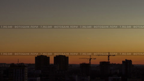 Городские силуэты домов и следы самолетов во время заката над городом, таймлапс. Стоковое видео, видеограф Кекяляйнен Андрей / Фотобанк Лори