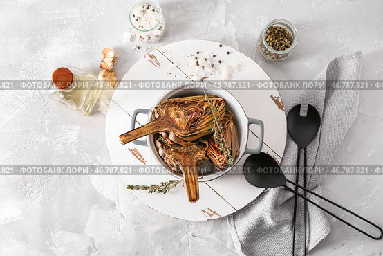 Горшок с вкусным запеченным артишоком на столе. Стоковое фото, фотограф Pixel_shot / Фотобанк Лори
