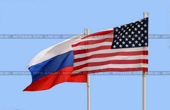 Государственные флаги Российской Федерации и Соединенных Штатов Америки рядом на фоне голубого неба. Стоковое фото, фотограф Щеголева Ольга / Фотобанк Лори