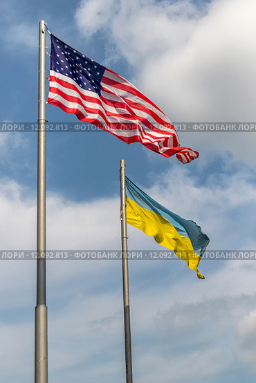 Государственные флаги Соединенных Штатов Америки и Украины рядом на фоне голубого неба (2015 год). Стоковое фото, фотограф Андрей Дегтярёв / Фотобанк Лори