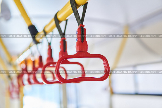 Grab handles in the passenger compartment of the bus on a blurred background. Стоковое фото, фотограф Евгений Харитонов / Фотобанк Лори