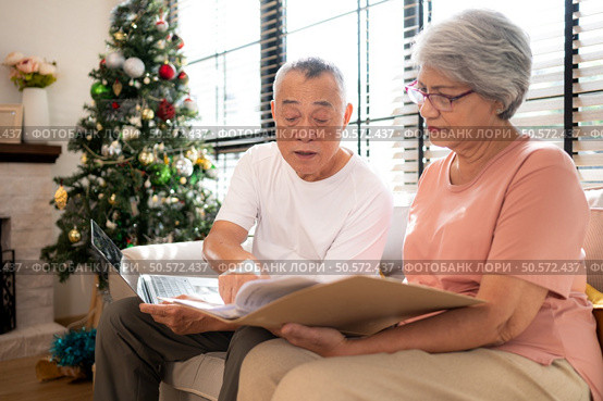 Grandfather and grandmother are reviewing the expenses and the food menu to host their children and grandchildren during the Christmas holiday at home. Стоковое фото, агентство Ingram Publishing / Фотобанк Лори