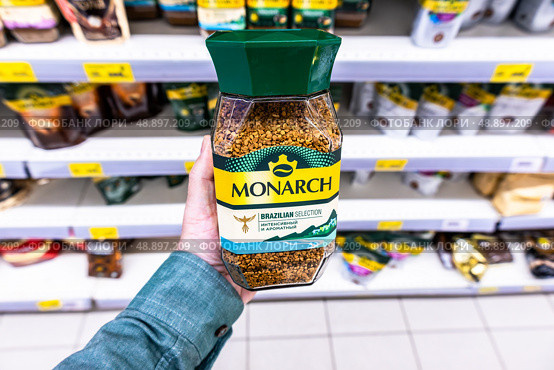 Гранулированный растворимый кофе Monarch в руке покупателя в продуктовом магазине. Редакционное фото, фотограф FotograFF / Фотобанк Лори