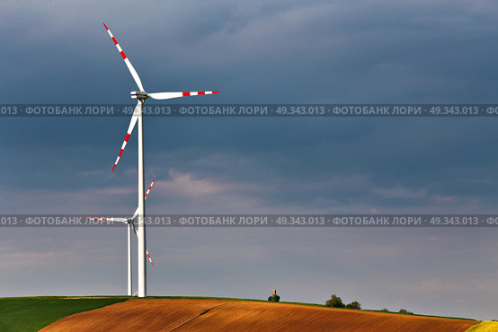 Green and yellow fields with Wind turbines generating electricity. Wind turbines before the thunderstorm. Spring sunny day on green field with wind power generators in Austria. Стоковое фото, агентство Ingram Publishing / Фотобанк Лори
