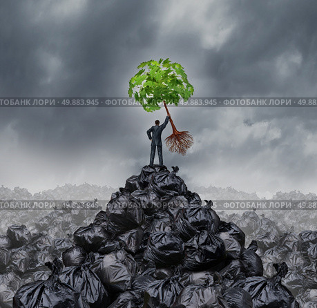 Green businessman concept as a man on top of a mountain heap of garbage holding up a green leaf tree with roots as an environment and conservation icon for waste management or a new healthy beginning. Стоковое фото, агентство Ingram Publishing / Фотобанк Лори