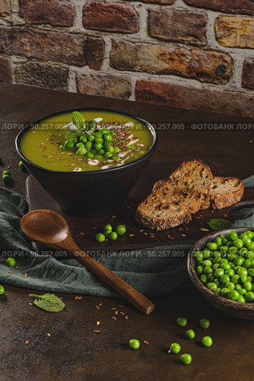 Green pea soup with linseed and pumpkin and sunflower seeds on a rustic kitchen countertop. Стоковое фото, агентство Ingram Publishing / Фотобанк Лори