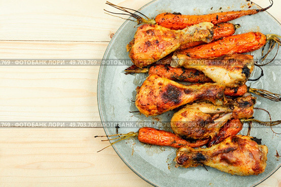 Grilled chicken drumsticks, roast chicken legs with carrots. Copy space. Baked chicken drumstick. Стоковое фото, агентство Ingram Publishing / Фотобанк Лори
