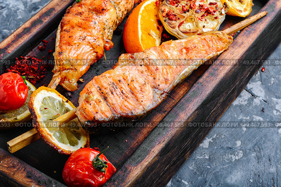 Grilled fish, grilled salmon steak with addition of lemon. Grilled salmon on skewer. Стоковое фото, агентство Ingram Publishing / Фотобанк Лори