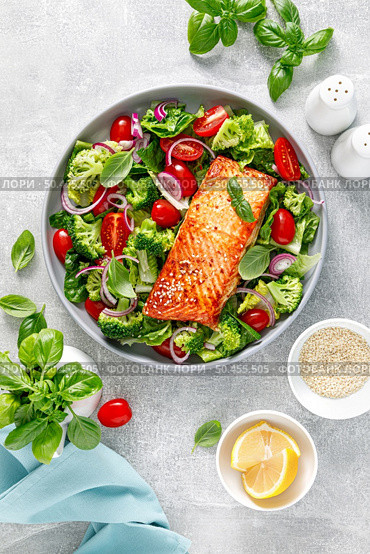 Grilled salmon fish fillet and fresh green leafy vegetable salad with tomatoes, red onion and broccoli. Healthy food. Ketogenic lunch. Top view. Стоковое фото, агентство Ingram Publishing / Фотобанк Лори