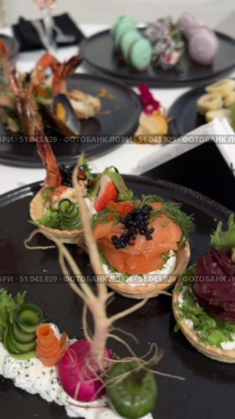 Grilled salmon steak with crispy skin sauteed vegetables and lemon served in outdoor restaurant in summer light A wooden table with a variety of dishes containing seafood, vegetables and fruit.Hand holding a spoon ready to eat pineapple fried rice with shrimp, served in a pineapple bowl, surrounded by fresh fruits and tea on a cozy table setting.Party Sea Food platter with salmon and prawns, low angle view, close-up Sea food party platter, extreme Whole poached salmon with cucumber slices for scales, high end party platter, overhead view Tiger prawns on the grill Macarooni cookies floating on blue background, levitation, macarooni cookies, dessert, sweets, colorful, delicious Two Glasses of Pink Champagne with Macarons and Oranges Elegant seaside celebration with seafood, pink floral decor, and sparkling wine overlooking the ocean. Стоковое видео, видеограф Zita Khasanova / Фотобанк Лори
